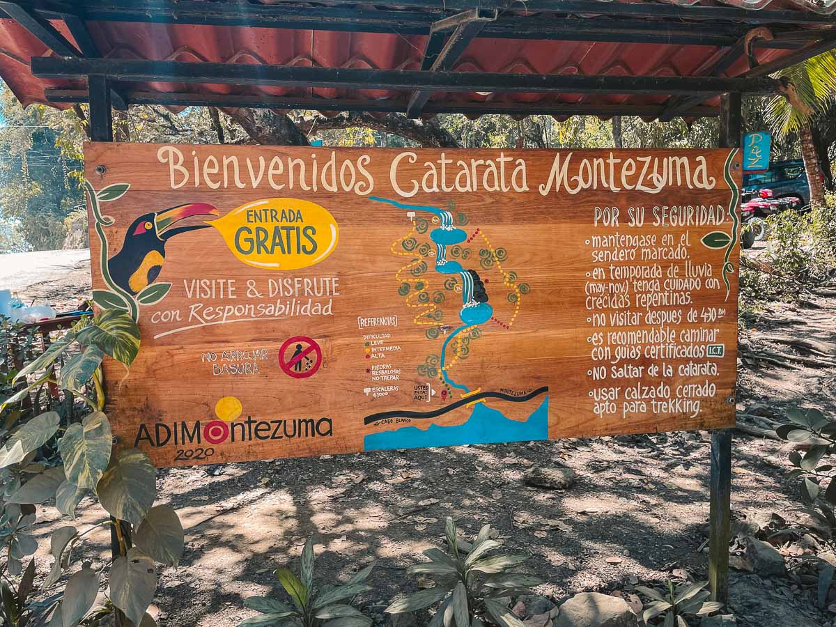 The map of Montezuma waterfalls at the entrance. It's colorful and on a piece of wood.