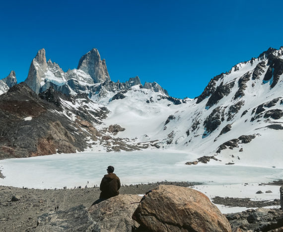 Me sitting at the edge of a rock over looking Laguna de los Tres and Fitz Roy.